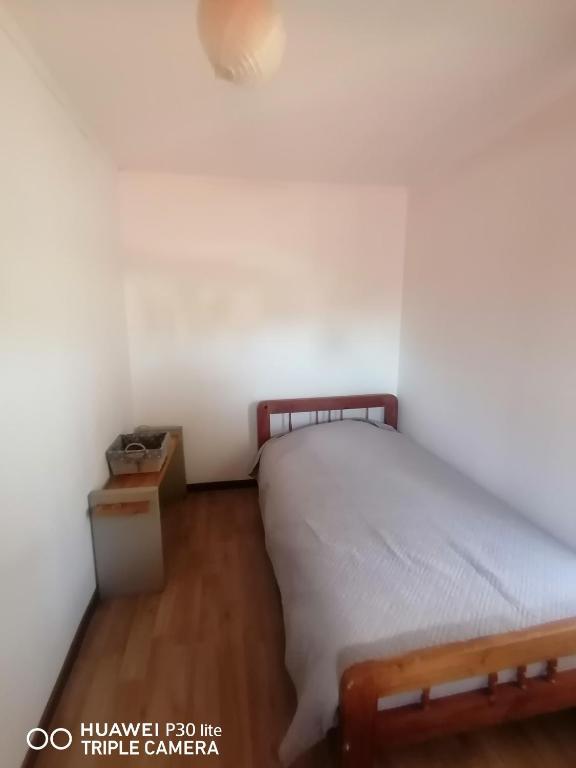 een kleine slaapkamer met een bed en een tafel bij Cabaña sector centro Villarrica in Villarrica
