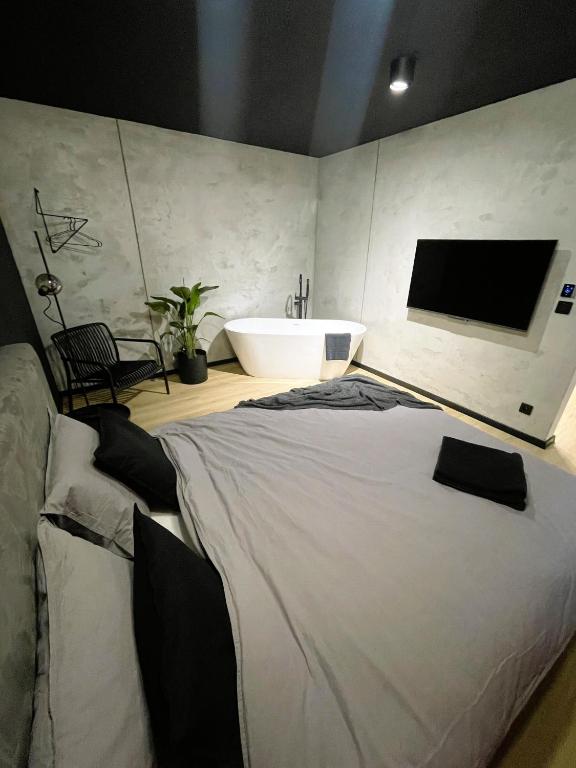 a bedroom with a large bed and a bath tub at Apartament Imperial Przedmieście in Grudziądz