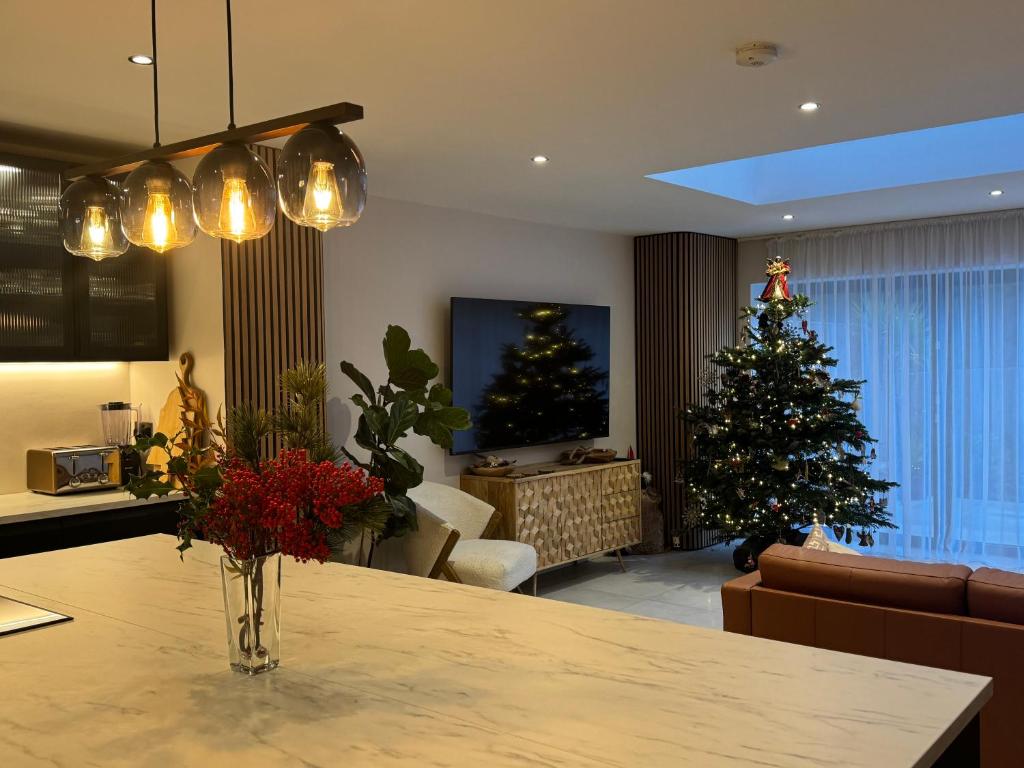 a living room with a christmas tree and a table at Modern Luxury Home with Spacious Garden close to Warner Bros Studio in Abbots Langley