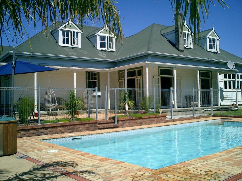 a house with a swimming pool in front of a house at Warkworth Lodge in Warkworth