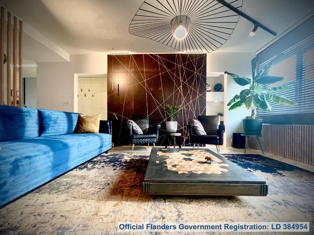 un salon avec un canapé bleu et une table dans l'établissement Desk Till Dawn, à Gand