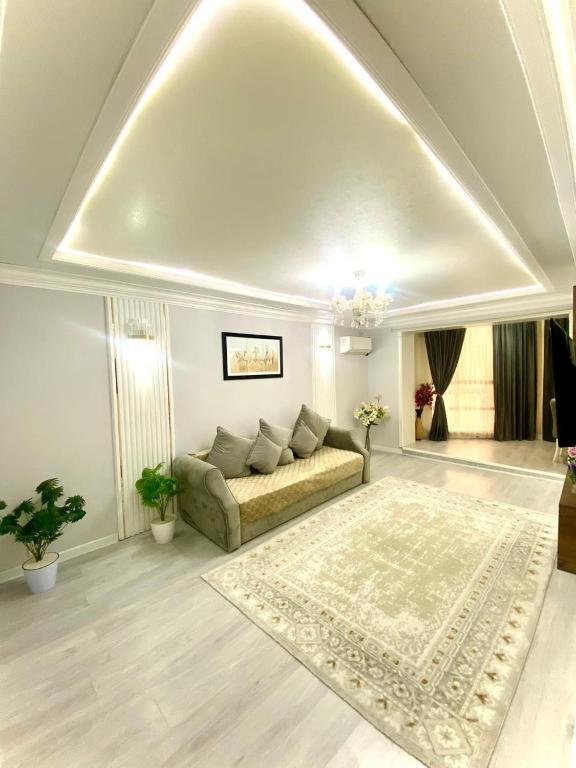 a living room with a couch and a rug at Апартамент Плаза 3 in Shymkent