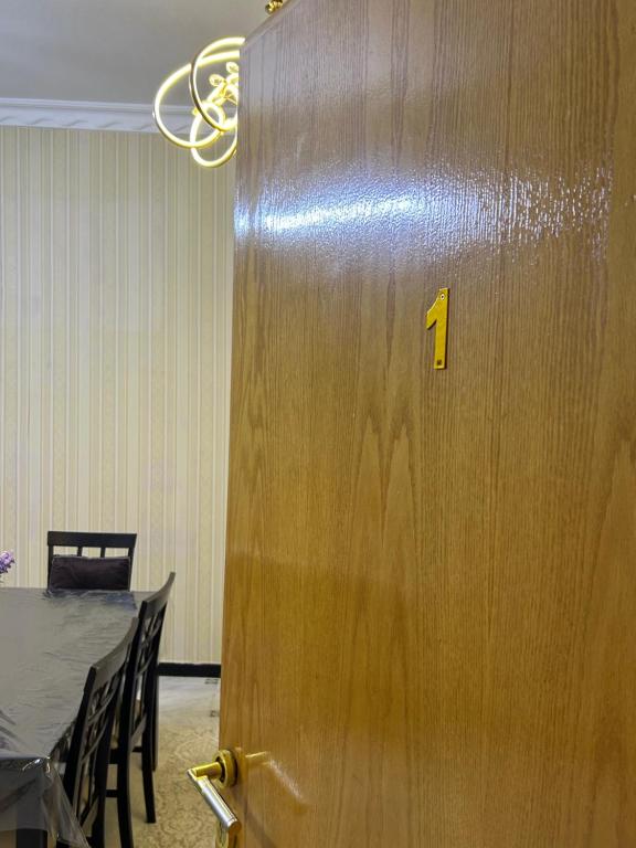 una porta di legno con un numero accanto a un tavolo di شقة مدخل خاص بمدخلين a Tanomah
