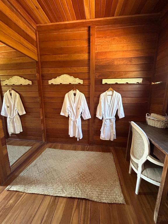 Chalé Vale da Mata - São Roque SP في ساو روكي: غرفة ذات جدران وأرضية خشبية وبها علاقتان