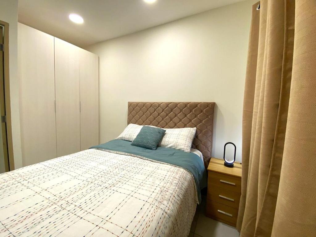 Un dormitorio pequeño con una cama y una cómoda. en Cozy house 5 minutes from the airport, en Las Flores