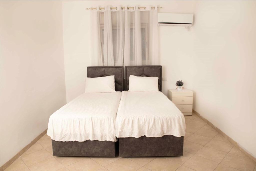 een slaapkamer met een groot bed met witte lakens bij מנוחה ומרגוע in Tiberias