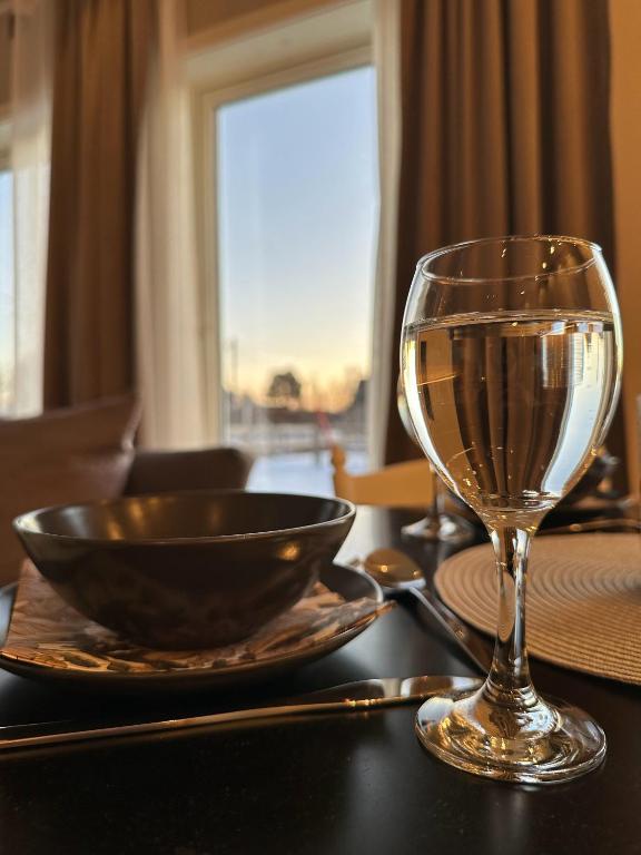 a glass of wine and a bowl on a table at Tindgaard apartment in Ørsvåg