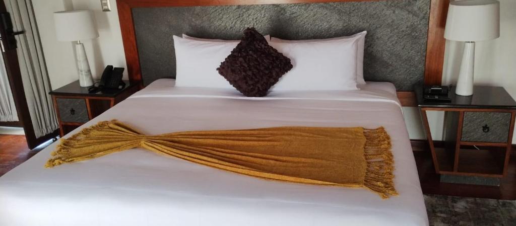 een wit bed met een bruine deken erop bij Mirtala Hotel Boutique in Guanajuato