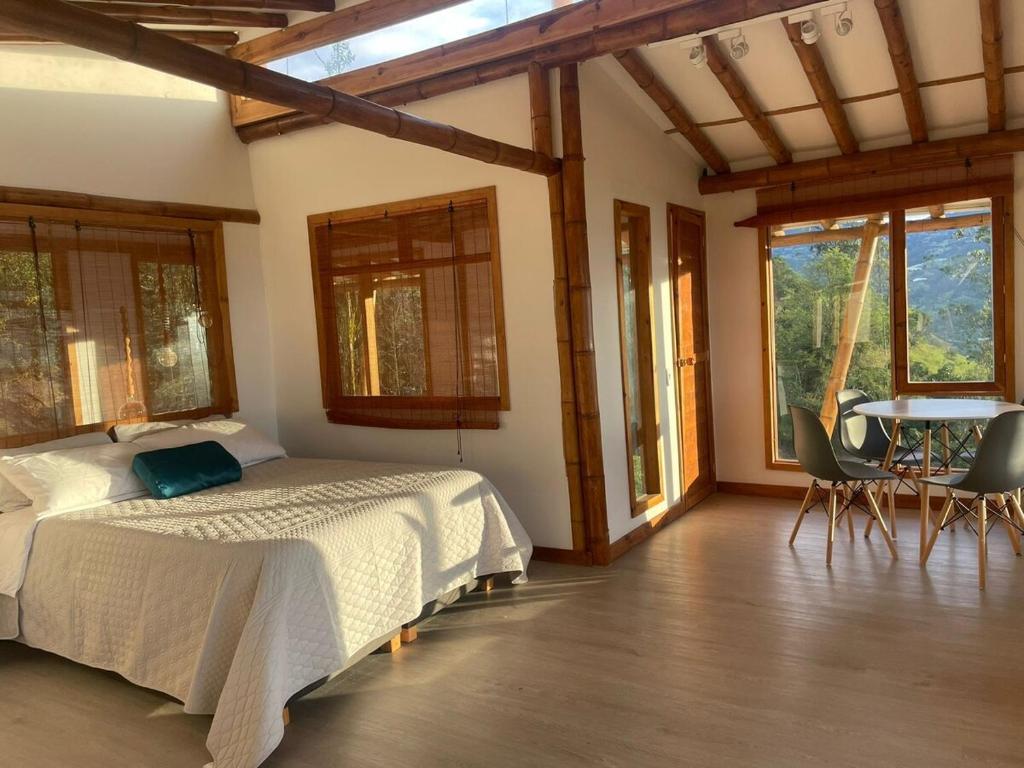 een slaapkamer met een bed, een tafel en stoelen bij Cabaña montaña Choachi in Choachí