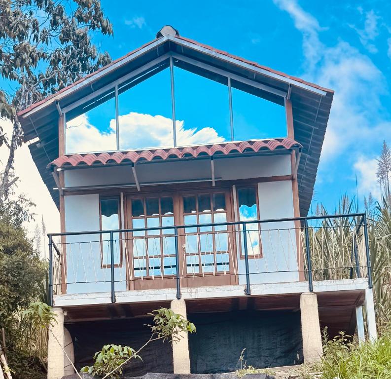 Cabaña Guanara في Vergara: فوقه منزل به نافذة كبيرة