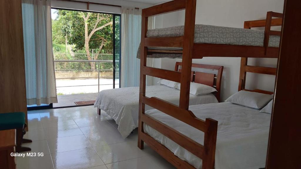 um quarto com dois beliches e uma janela em Paraiso Escondido Guachaca em Guachaca