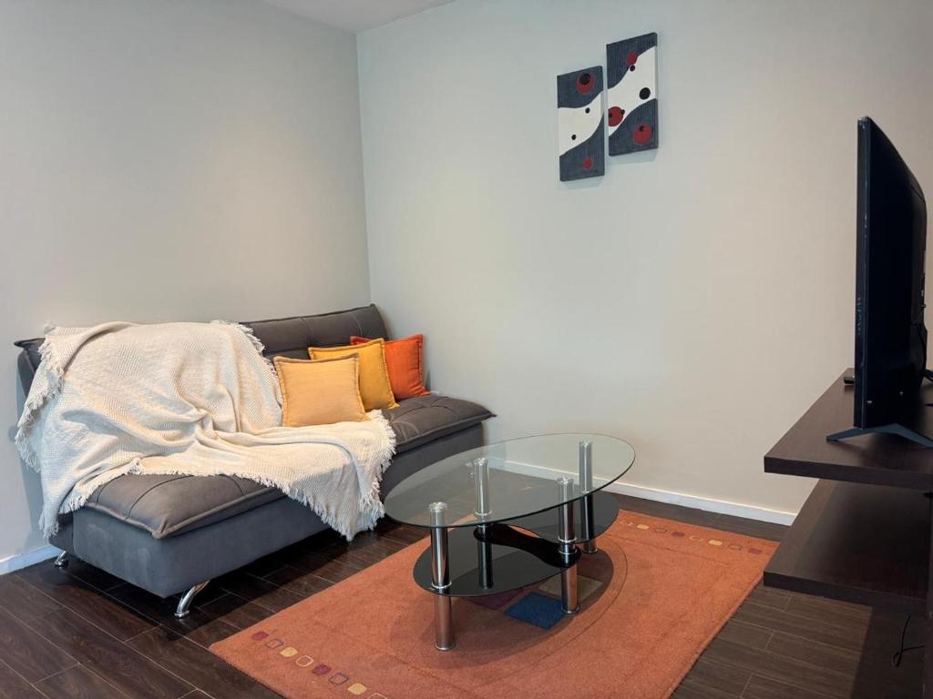 a living room with a couch and a glass table at 7th floor Live, Laugh and Relax in Cochabamba