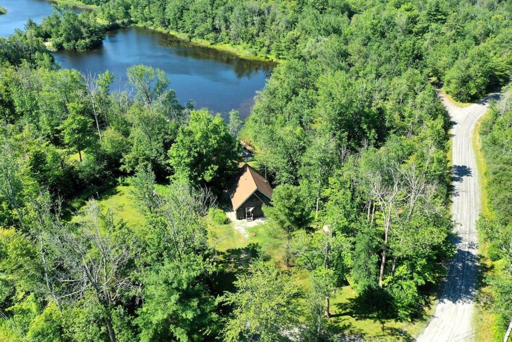 - une vue aérienne sur une maison à côté d'un lac dans l'établissement Little Longbow Lakefront Chalet, à Becket