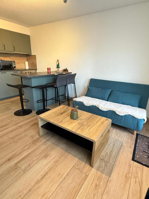 een woonkamer met een blauwe bank en een tafel bij Torrent House in Bouveret