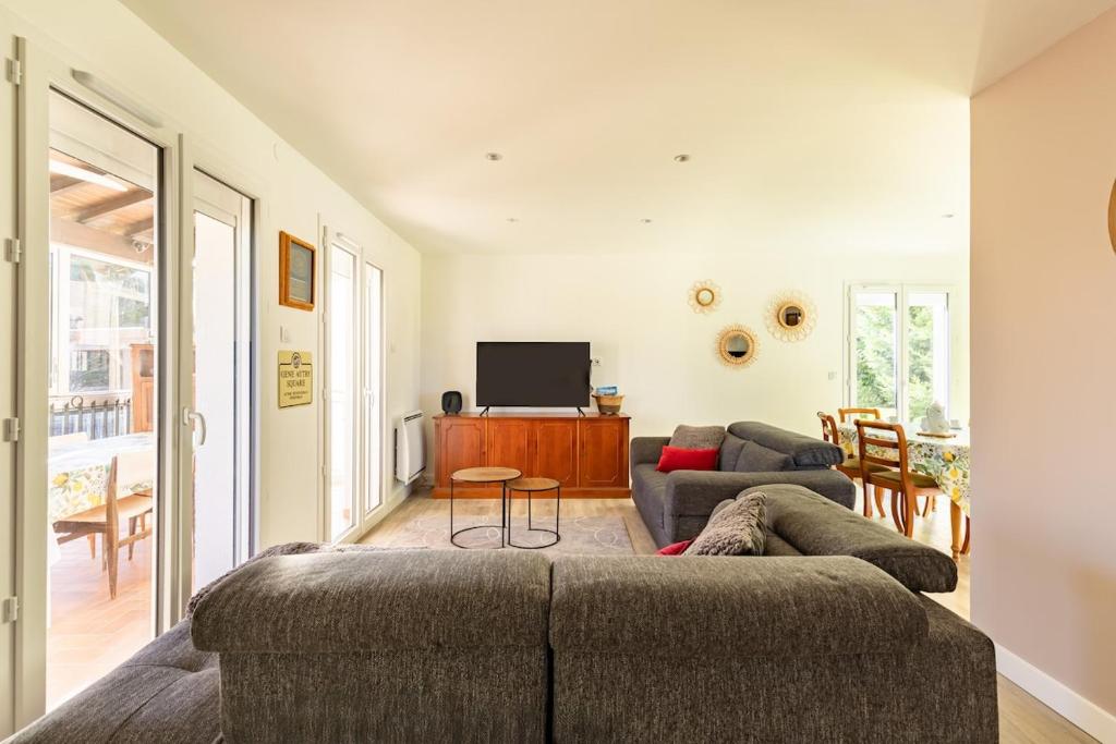 un salon avec un canapé et une télévision dans l'établissement Maison Baqué, à Carbonne
