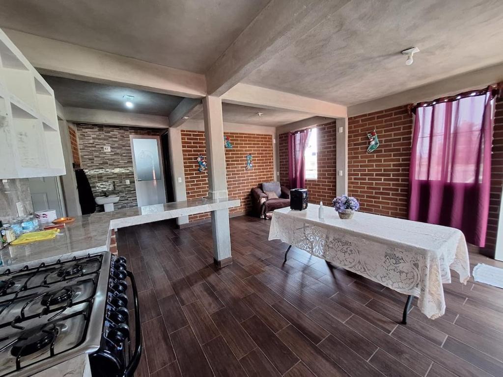 a kitchen with a table in the middle of a room at departamento 2 en condominio in Amecameca de Juárez