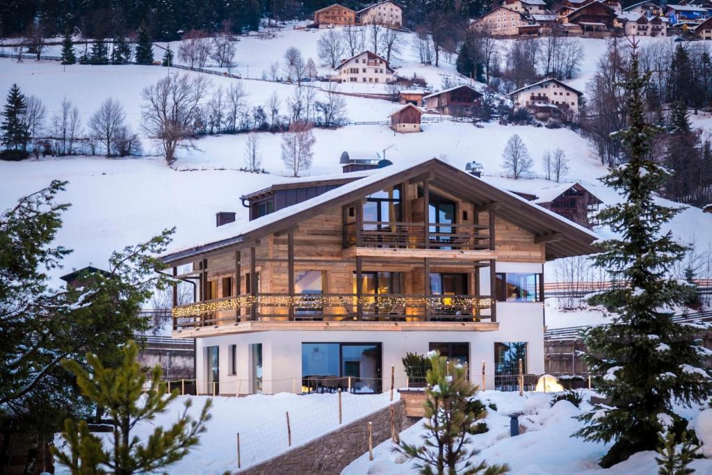 een huis op een heuvel met sneeuw op de grond bij Chalet Bel Plan in Ortisei