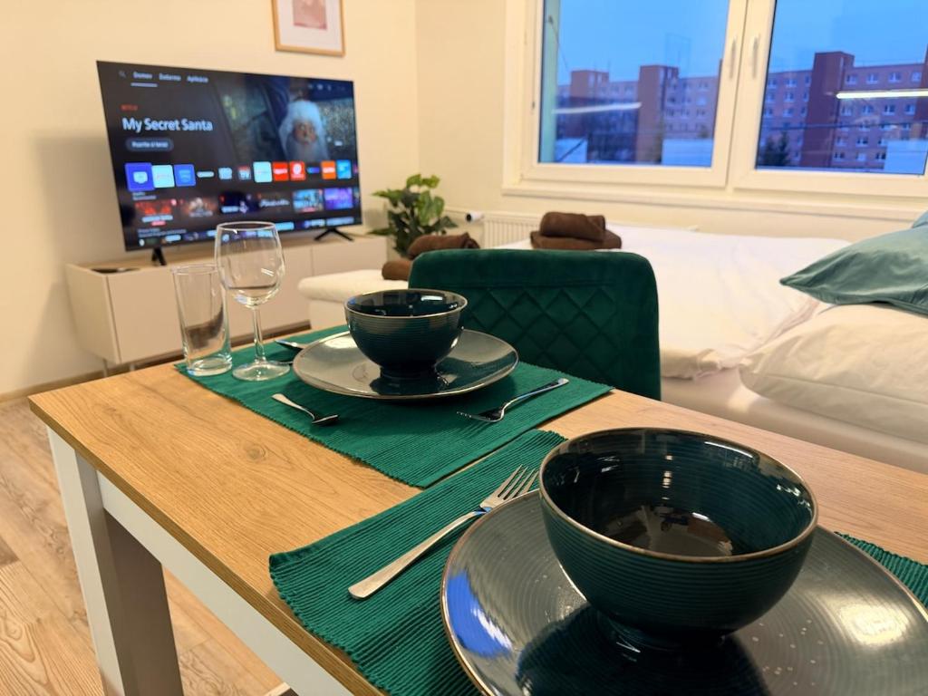 une table de salle à manger avec deux assiettes et un bol de nourriture dans l'établissement SkyView Studio Vlčince with private parking, à Žilina