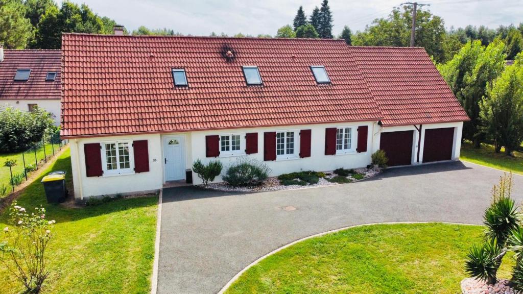 a house with a red roof and a driveway at Maison familiale à la campagne in Donnery