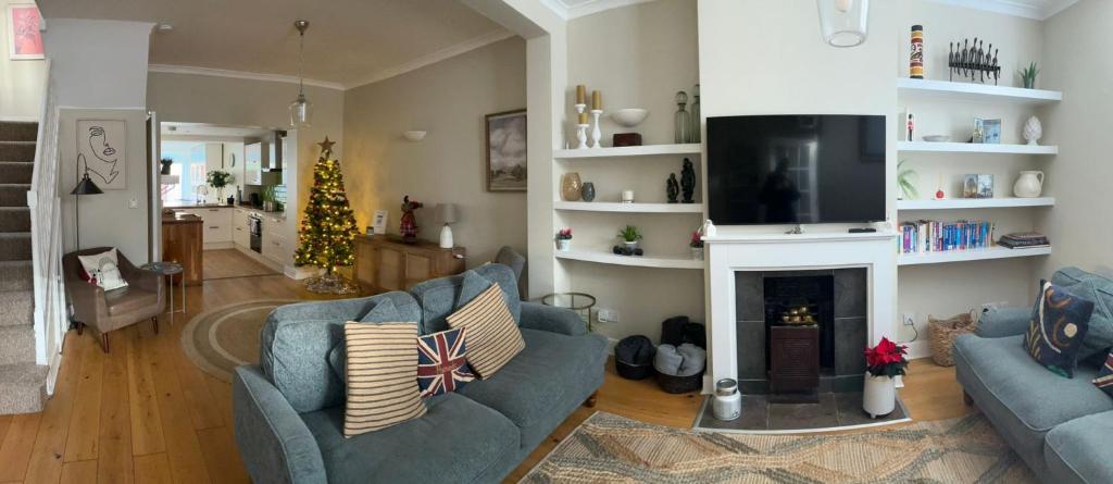 a living room with two blue couches and a fireplace at STYLISH 3 BED COTTAGE, WALK 2 ALL SIGHTS & HIGH ST in Windsor