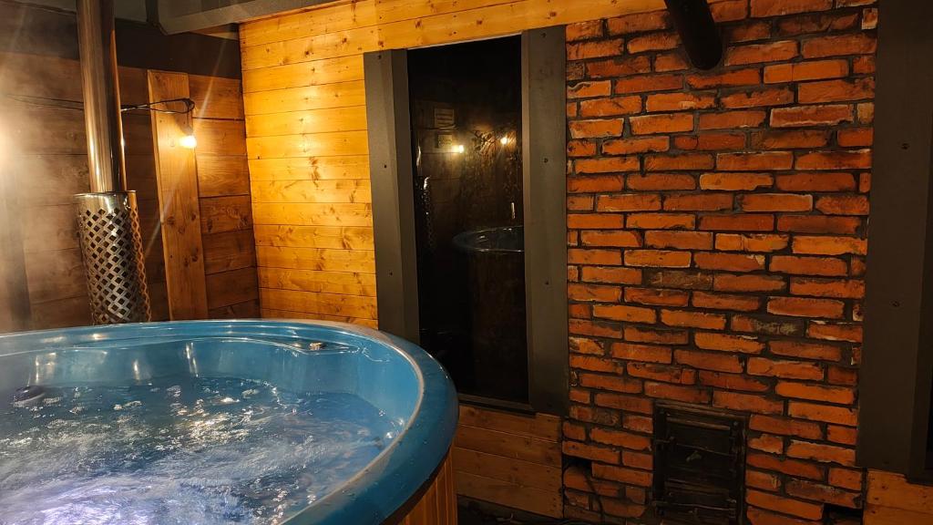 a hot tub in a room with a brick wall at Loft House Rozewie , BALIA OGRODOWA,oraz SAUNA in Jastrzębia Góra