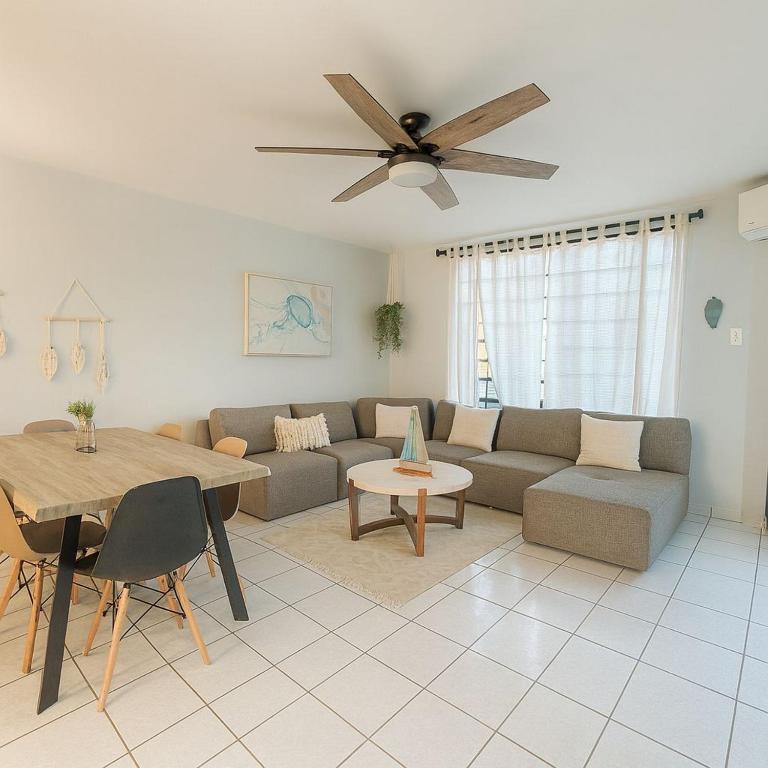 a living room with a couch and a table at Tropical Tranquility - Corcega in Stella
