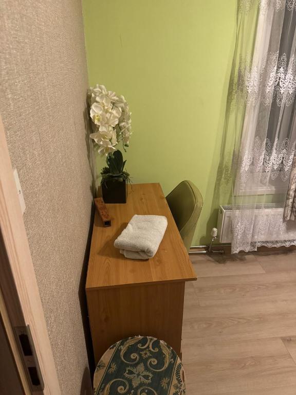 a wooden table with a vase of flowers on it at Room in Northampton in Great Billing