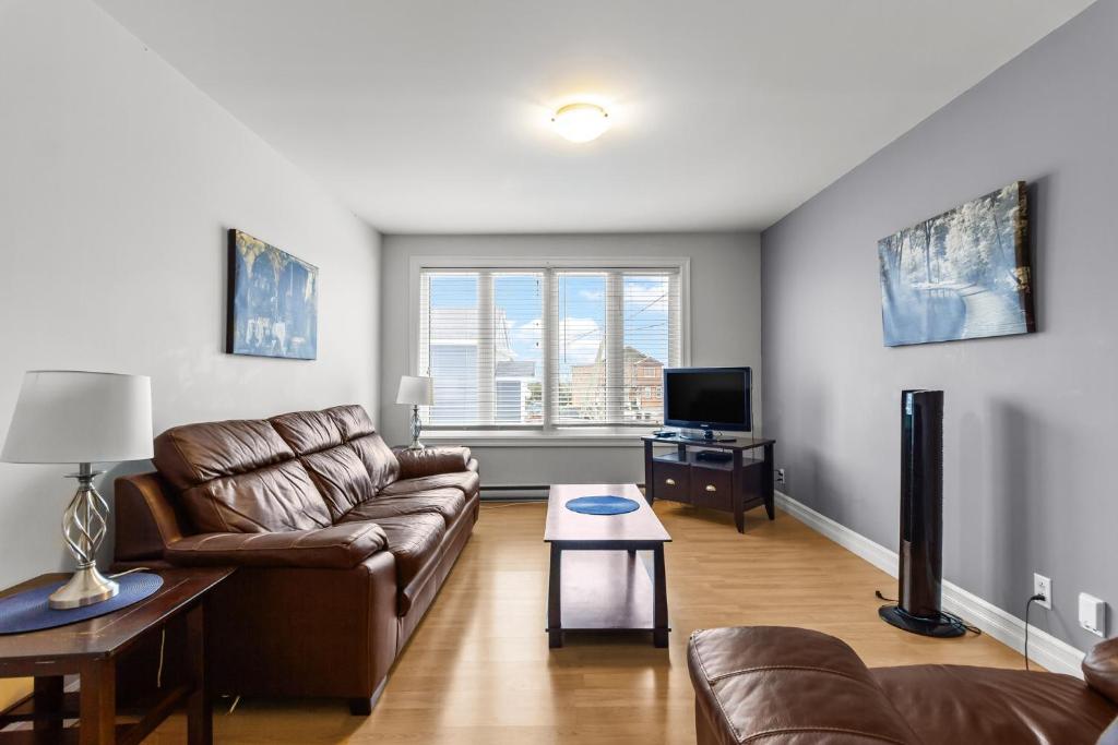 a living room with a couch and a tv at Relaxing 2BR Parking Self Check-In in Torbay