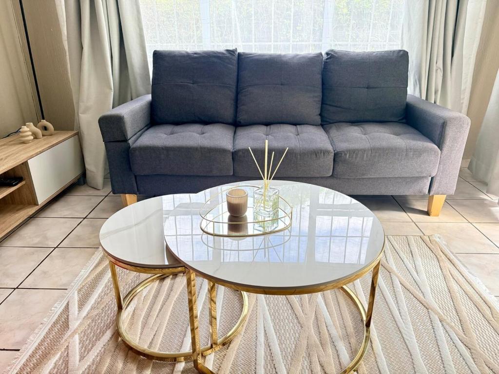 a living room with a couch and a glass table at Royaltics place in Weltevredenpark
