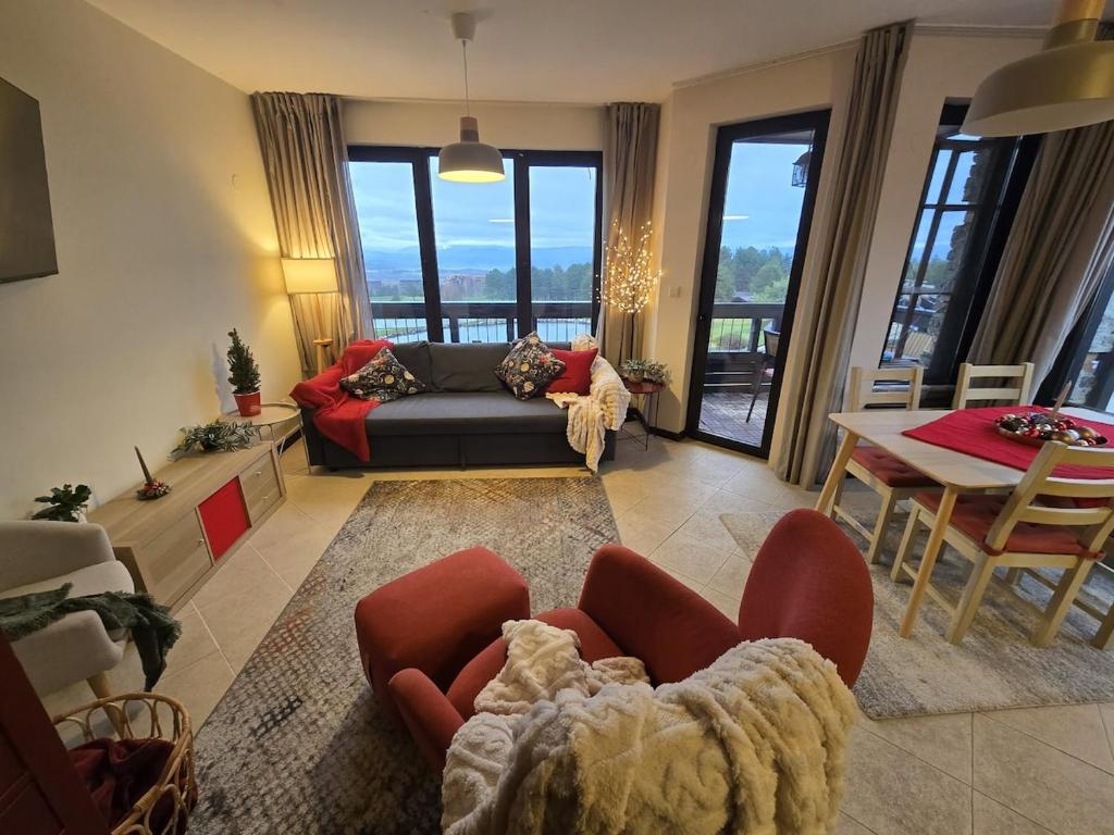 a living room with a couch and a table at Tranquility Apartment Pirin Golf in Razlog