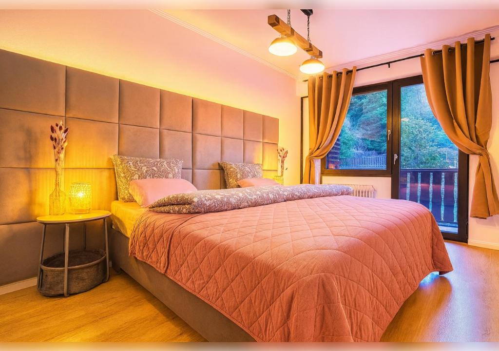 a bedroom with a large bed and a large window at 21 Gramm Das Verborgene mit Tiefgarage in Sasbachwalden