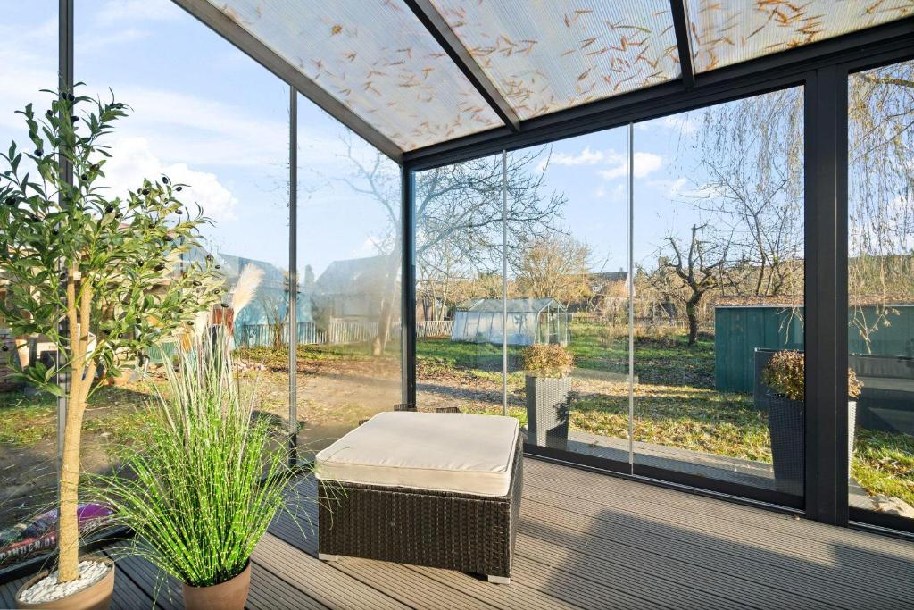 a room with large windows and a chair on a deck at Ferienwohnung-Finn-EG in Rechlin