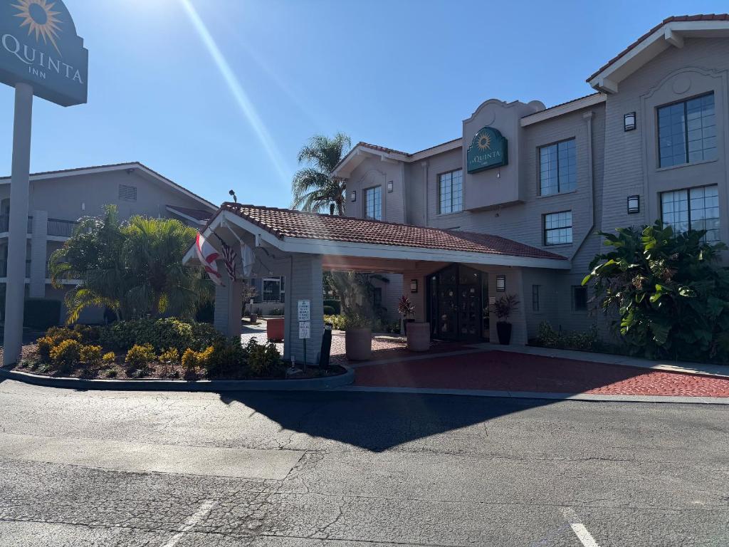a hotel building with a flag in a parking lot at La Quinta by Wyndham Pinellas Park St Peterburg Clearwater in Pinellas Park