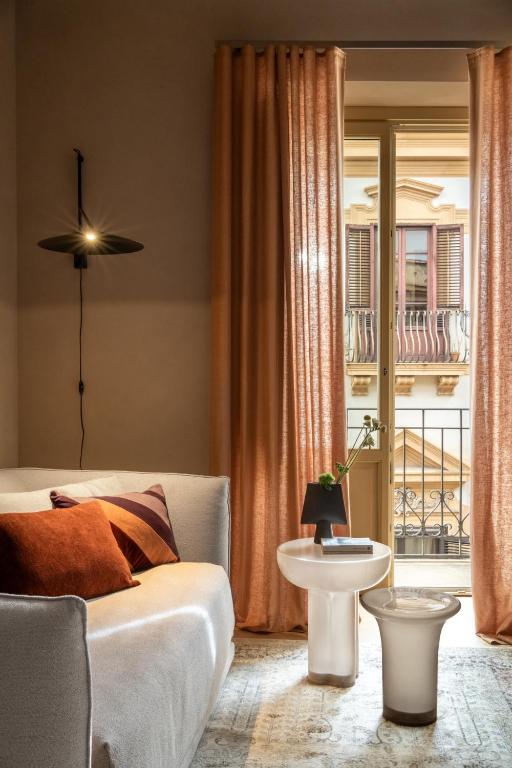 a living room with a bed and a table at Palazzo Balsamo Boutique Hotel in Palermo