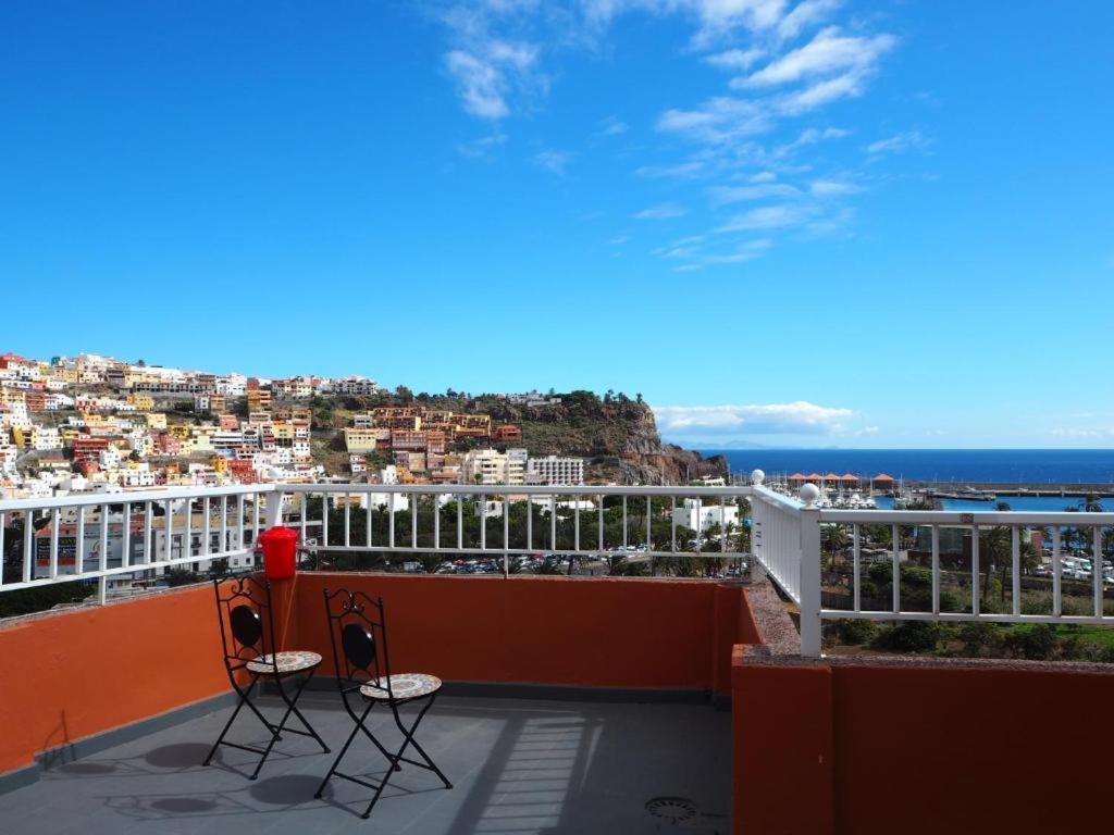 2 stoelen op een balkon met uitzicht op de stad bij apartamentos la villa in San Sebastián de la Gomera
