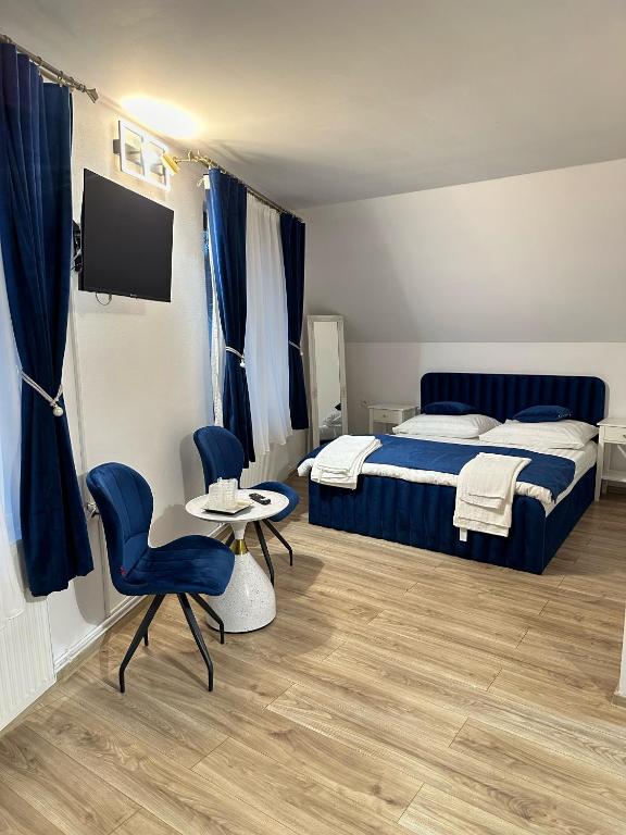 a bedroom with a bed and a table and chairs at Tudor's Rooms in Mediaş