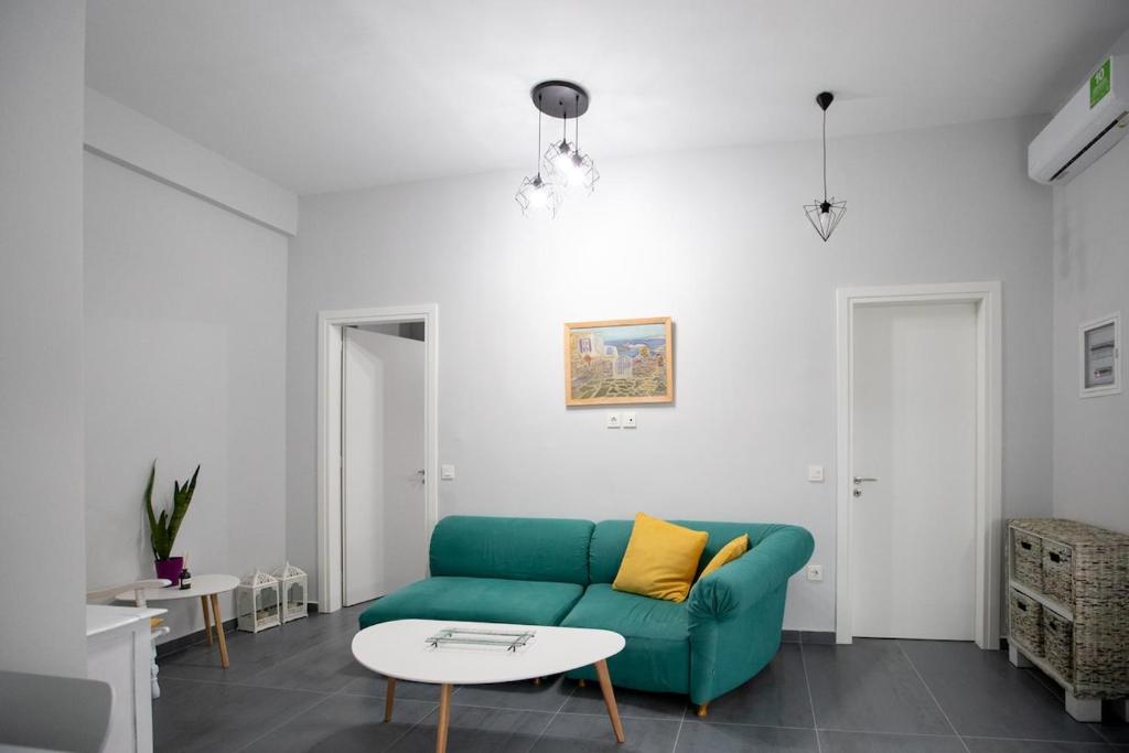 a living room with a green couch and a table at Perivola apartment in Patra