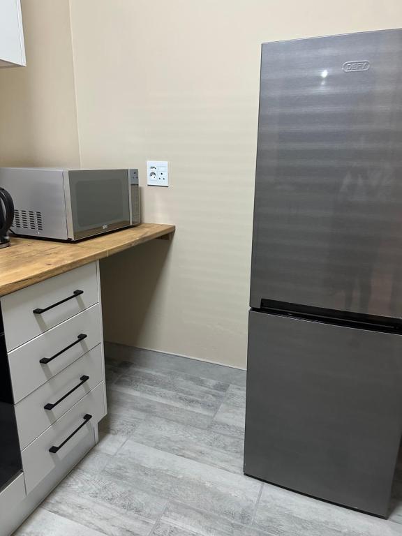 a kitchen with a refrigerator and a microwave on a counter at Guesthouse Le Michele in Swakopmund