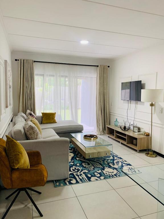 a living room with a couch and a table at 2 Bed 2 Bath Private Garden Apartment in Fourways