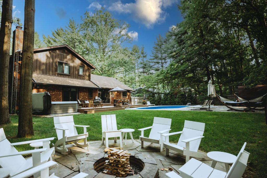 Loma House في Sawyer: حديقة خلفية وكراسي بيضاء وحفرة نار