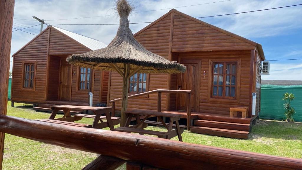 una cabina di legno con tavolo e ombrellone di Cabaña Isi Cdelu a Concepción del Uruguay