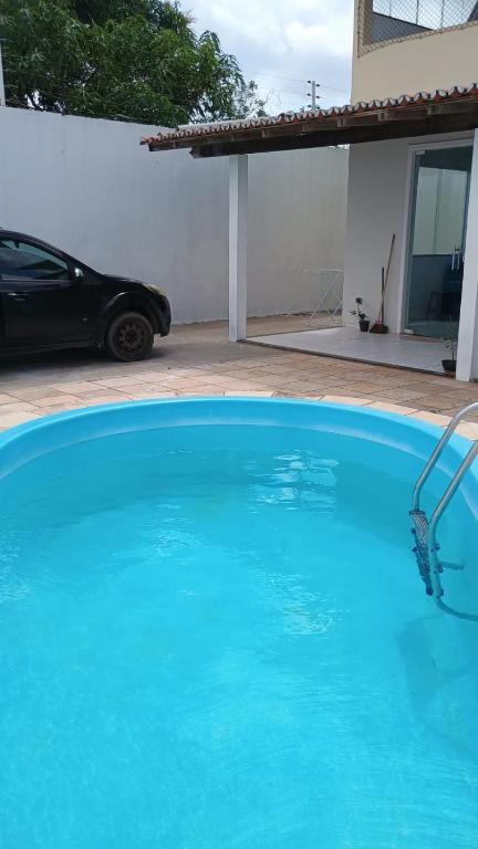 a large blue swimming pool in front of a house at Bela Casa PX as praias in São Luís