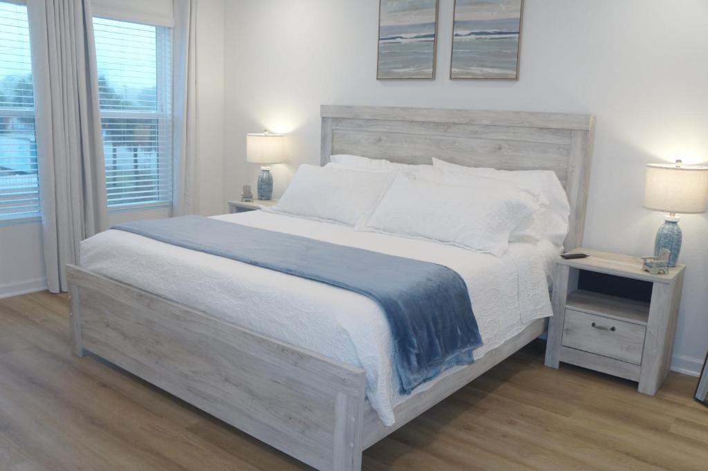 Townhome near beach and The Wharf Amphitheater! في شاطئ أورانج: غرفة نوم بسرير ابيض كبير ومصباحين