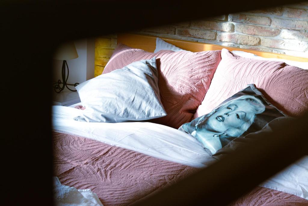 a bed with a picture of a woman on it at The Bohemian Residence in Belgrade