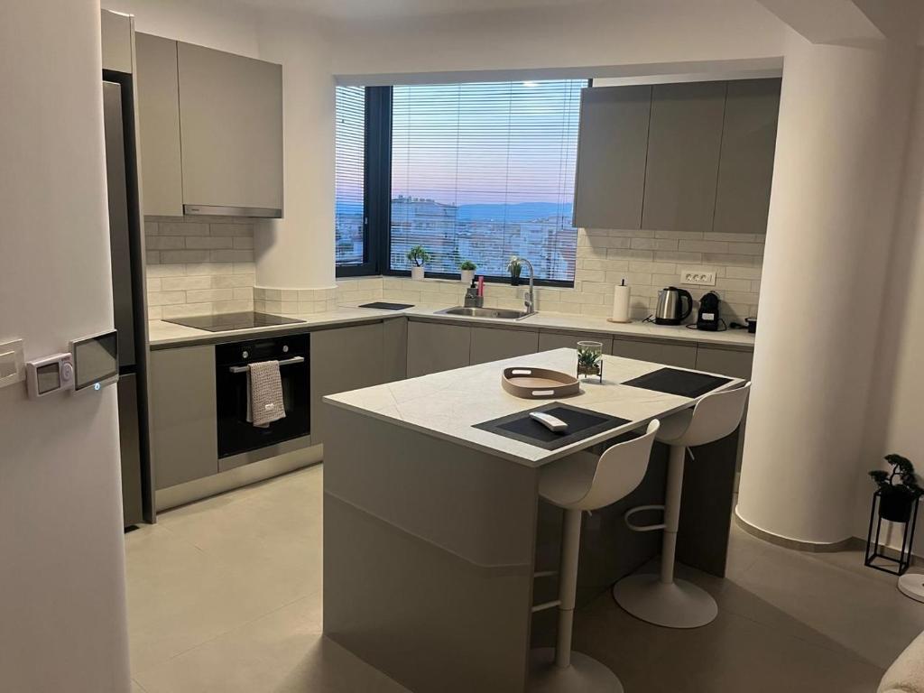 eine Küche mit einer Theke und einem großen Fenster in der Unterkunft Luxury Loft 7-8 in Tríkala