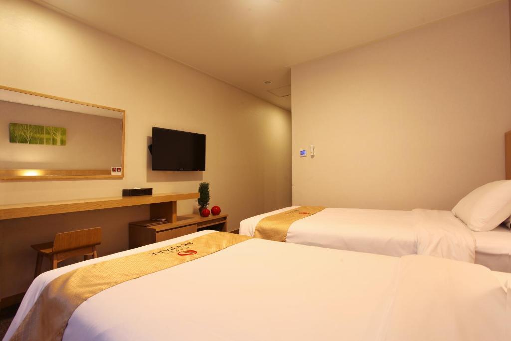 Postel nebo postele na pokoji v ubytování Hotel Skypark Jeju 1