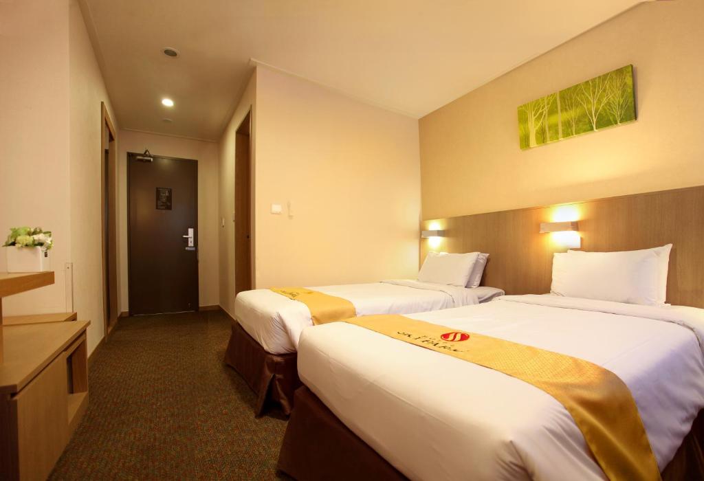 Postel nebo postele na pokoji v ubytování Hotel Skypark Jeju 1