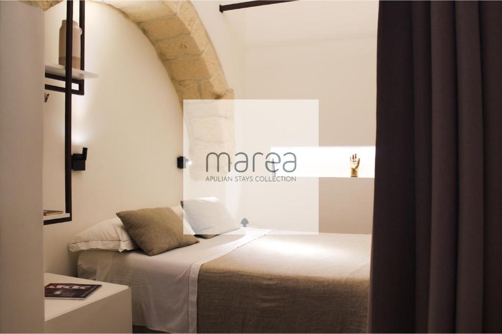 um quarto com uma cama com uma placa na parede em I Granai, dimora con vasca idromassaggio - Marea Stays Collection em Nardò