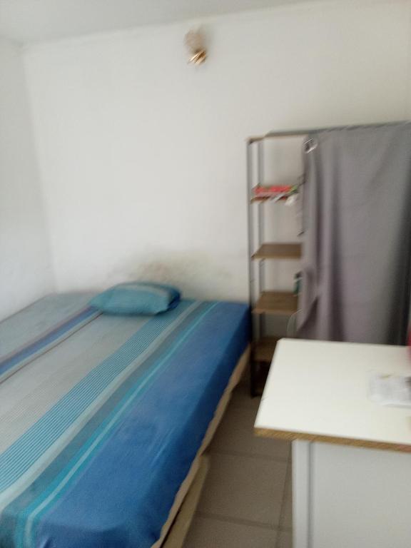 a small room with a bed and a table at Chambre sur FDF in Fort-de-France