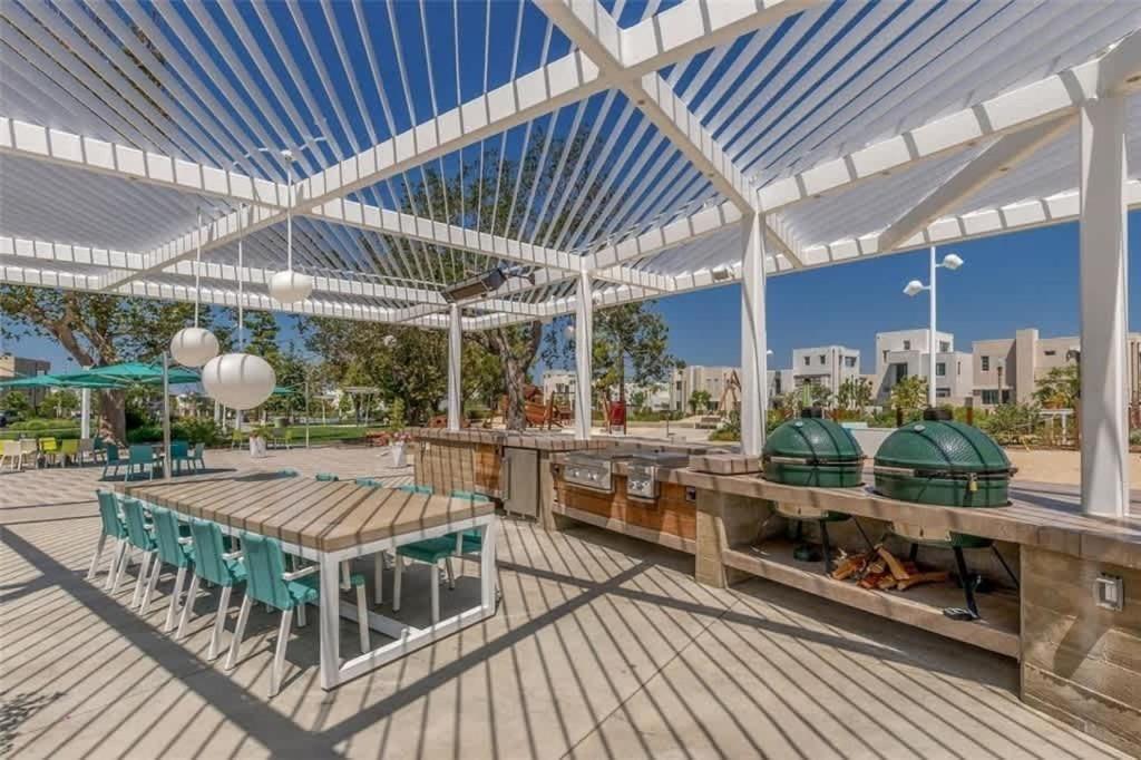 a pavilion with tables and chairs on a wooden deck at Marbella Lane Chic Stay In Prime Irvine Area in Lake Forest